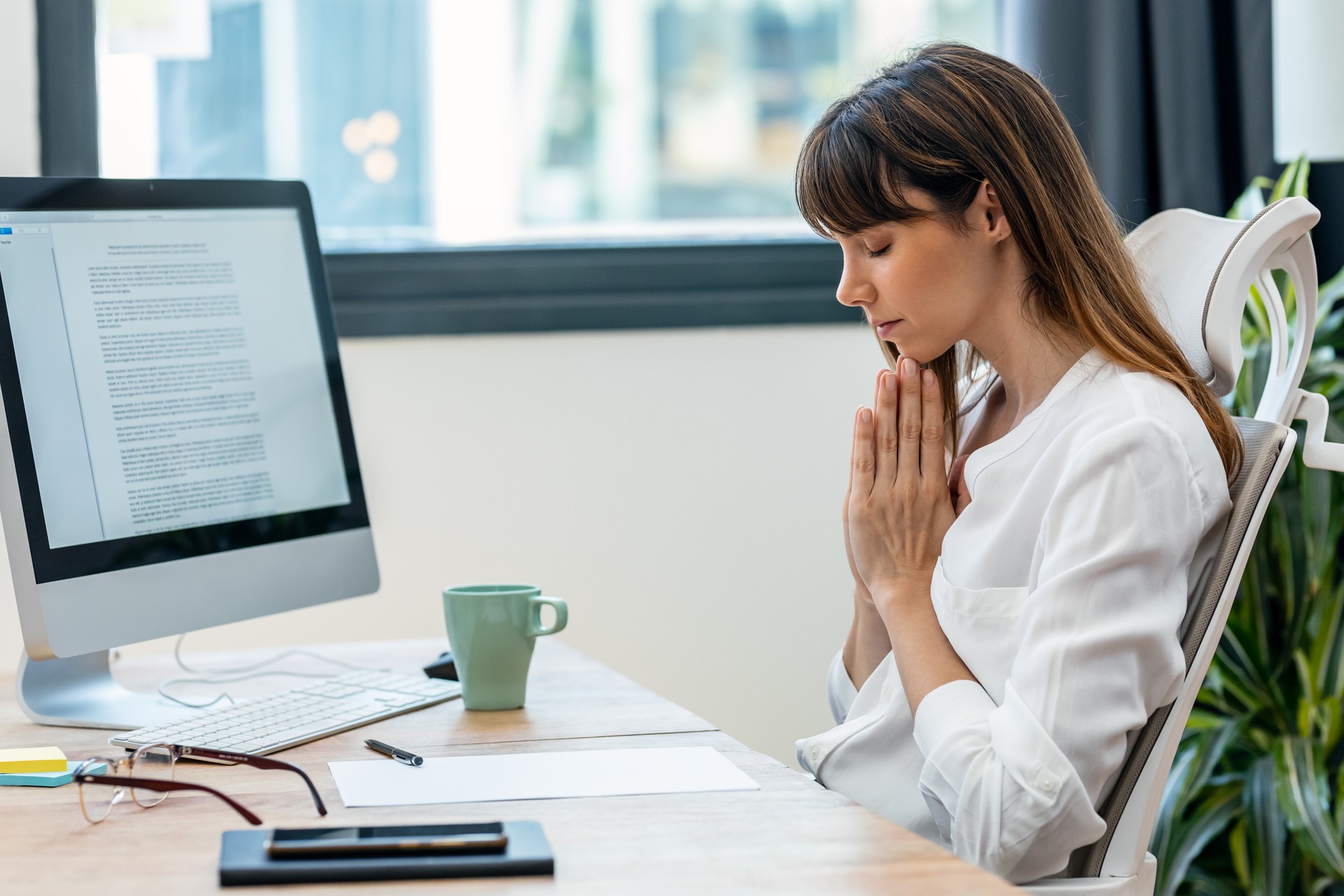 Beautiful smart nutritionist woman doing meditation while working with computer in a nutritionist consultation