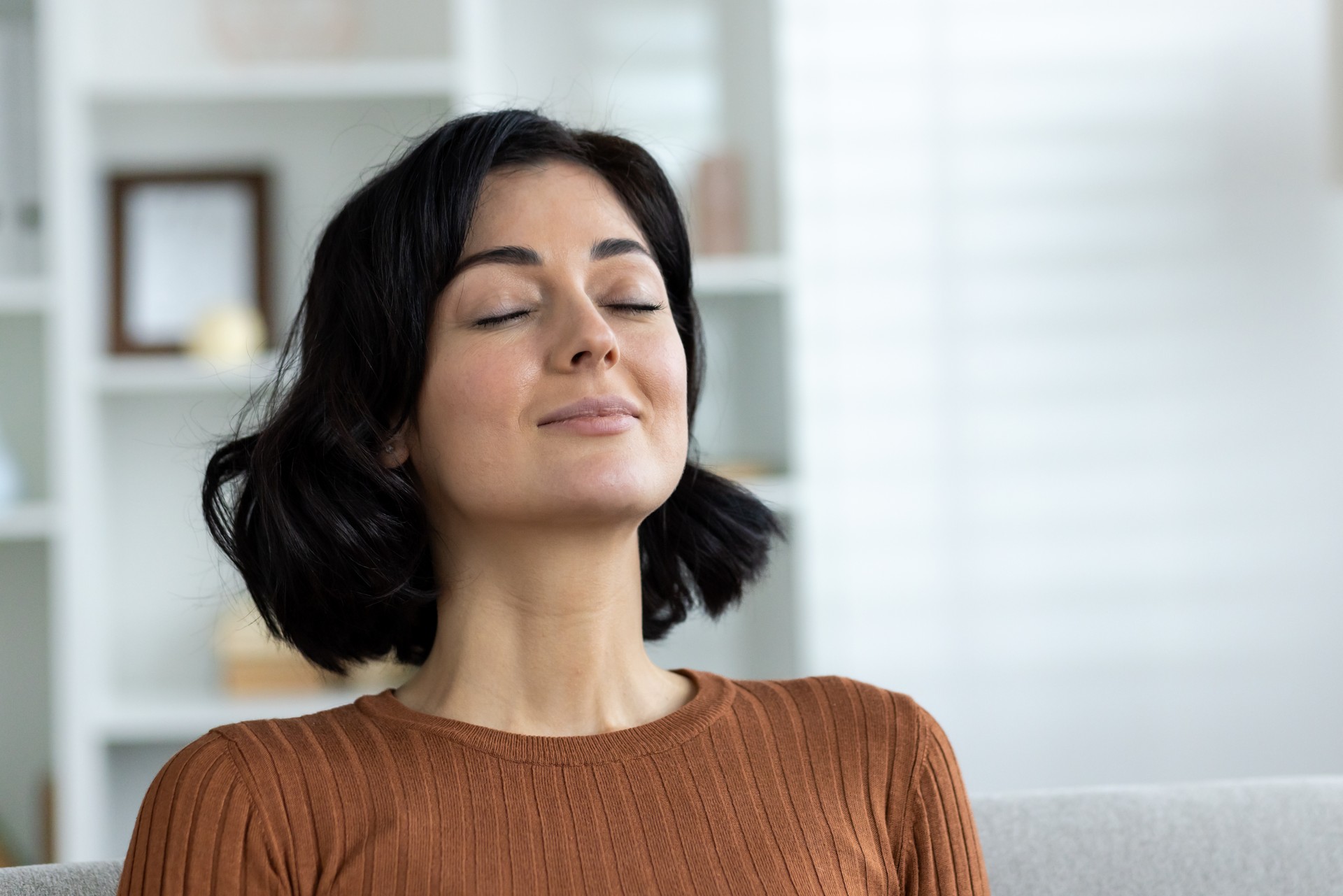 Woman with closed eyes practicing mindfulness and relaxation at home